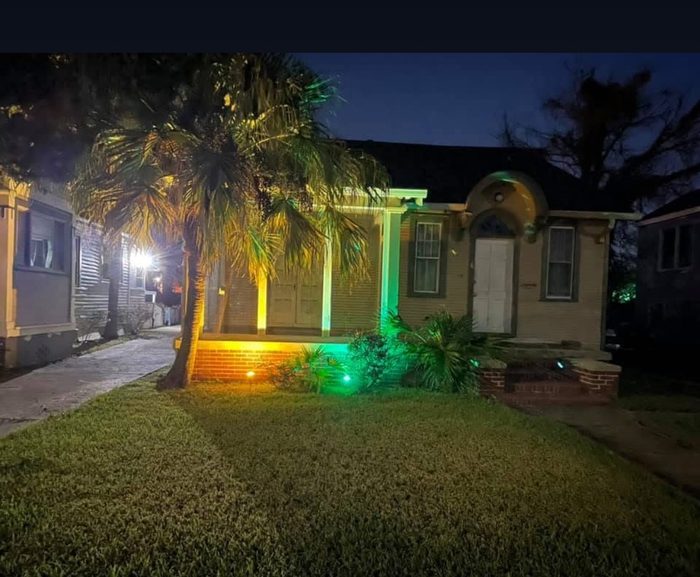 Palm tree and porch uplighting installed by TK Electric, shown at night