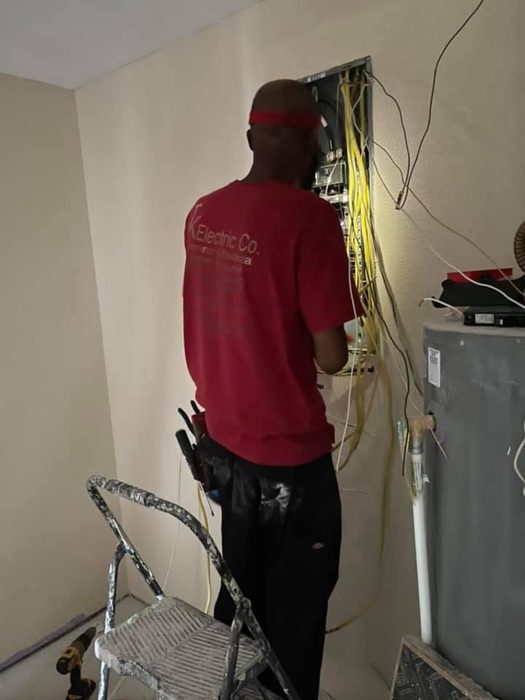 TK Electric technician working inside an open panel during installation
